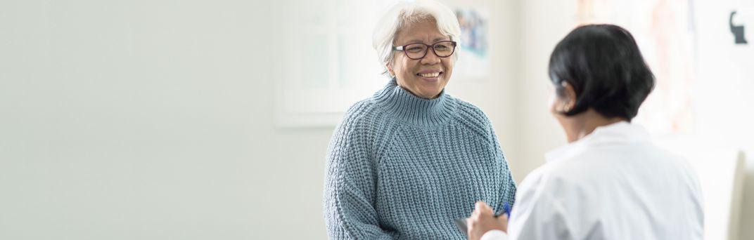 A senior citizen smiles at her doctor at a medical appointment.
